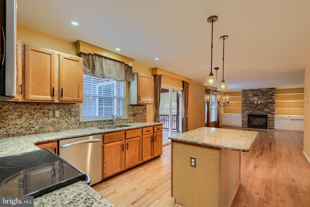 kitchen featuring a kitchen island, pendant lighting, dishwasher, sink, and light wood-type flooring