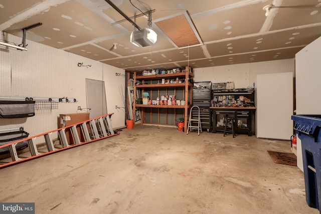 garage with a garage door opener and a workshop area