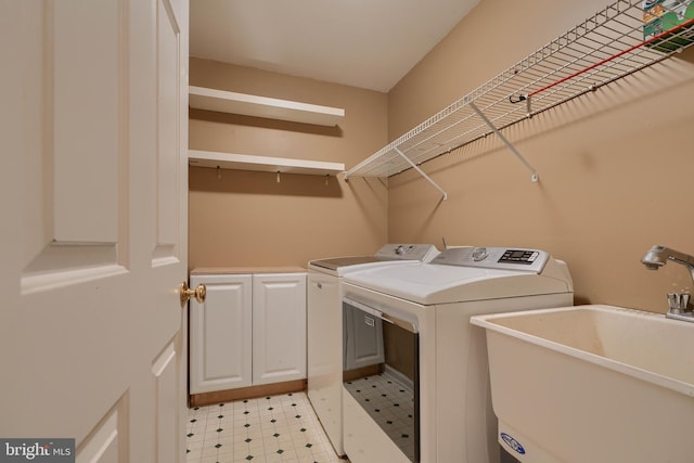 laundry area featuring cabinets, sink, and washer and dryer