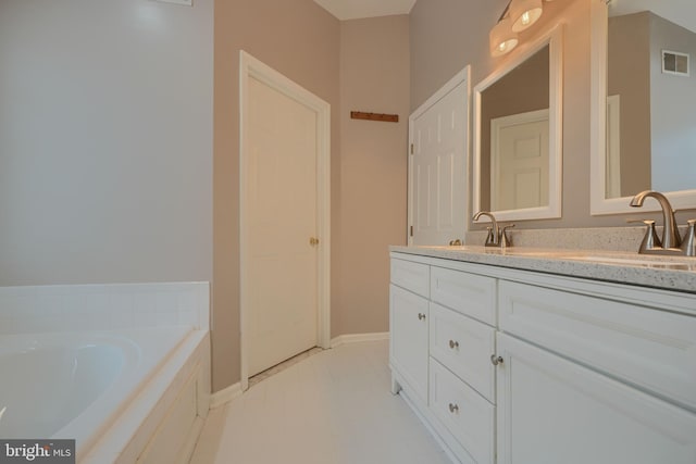 bathroom featuring tile patterned flooring, vanity, and a washtub