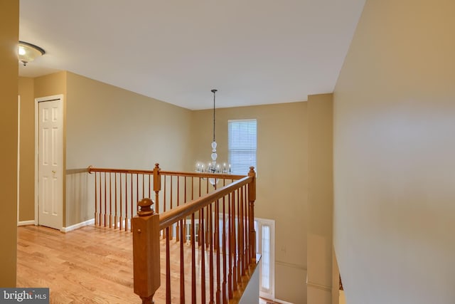 staircase with hardwood / wood-style flooring and a notable chandelier