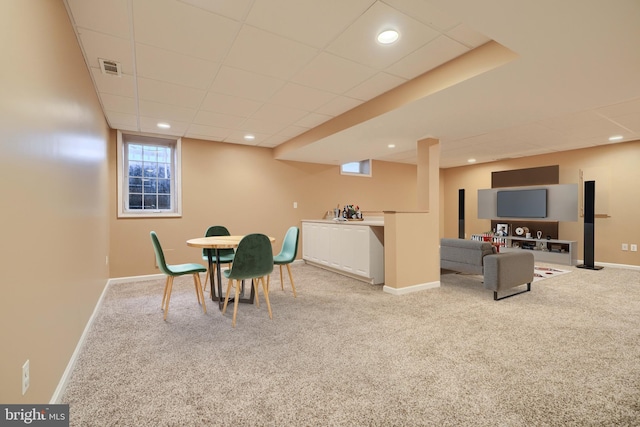 carpeted dining room with a paneled ceiling