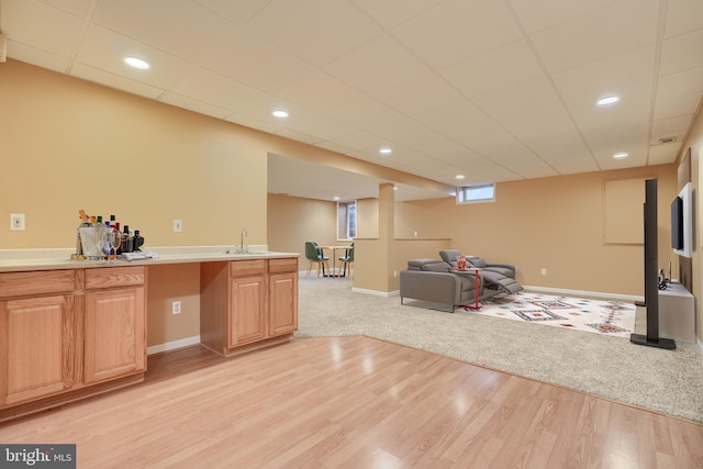 interior space featuring a paneled ceiling, light hardwood / wood-style floors, and sink