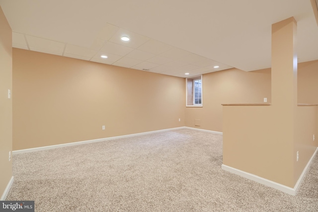 basement with a drop ceiling and carpet