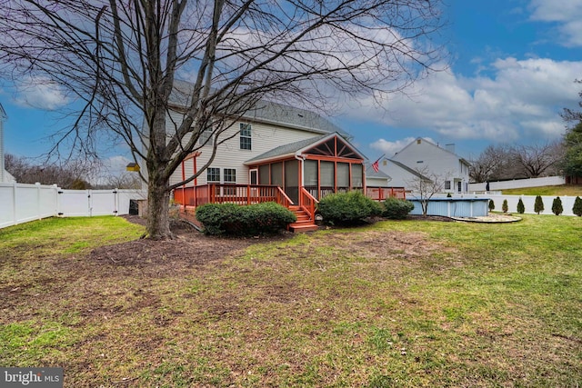 view of yard featuring a pool side deck and a sunroom