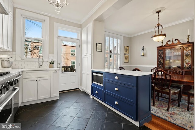 kitchen featuring crown molding, light countertops, stainless steel range, and blue cabinetry