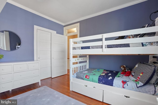 bedroom featuring crown molding and wood finished floors