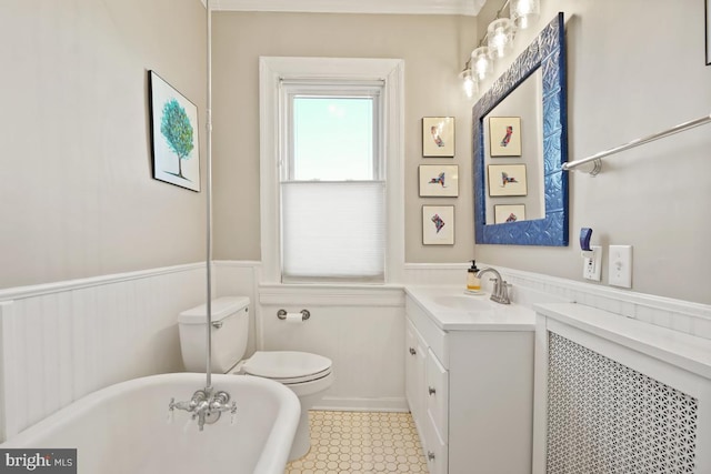 full bathroom featuring a wainscoted wall, a soaking tub, vanity, and toilet