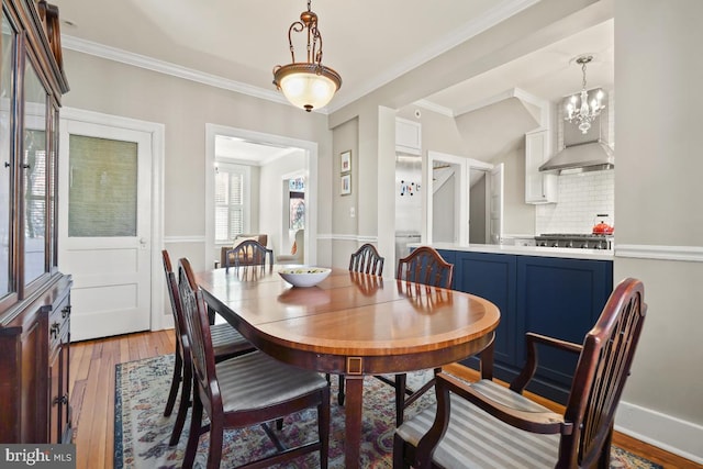 dining area featuring ornamental molding and light wood-style flooring