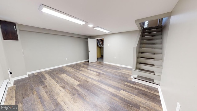 basement featuring a baseboard radiator and hardwood / wood-style floors