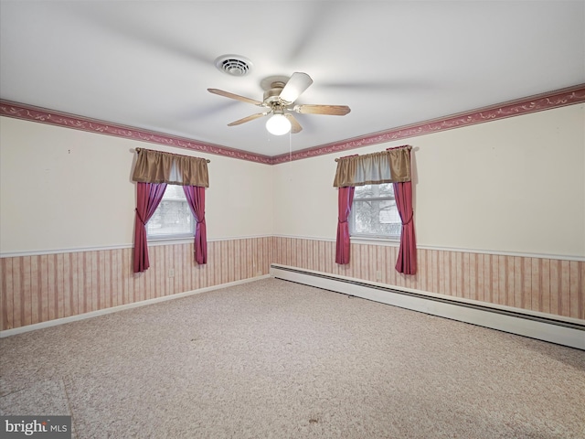 spare room with carpet floors, ceiling fan, and baseboard heating