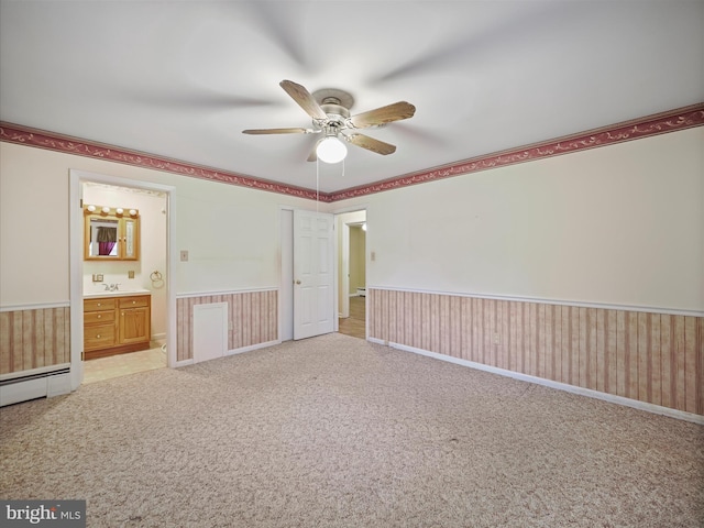 unfurnished bedroom with sink, ensuite bath, light colored carpet, and ceiling fan