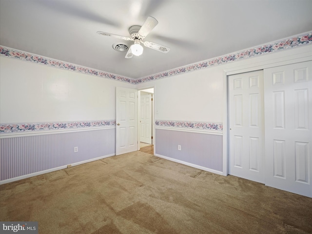 unfurnished bedroom featuring light carpet, a closet, and ceiling fan