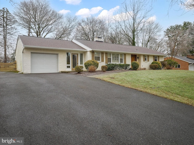 ranch-style home featuring a garage and a front yard