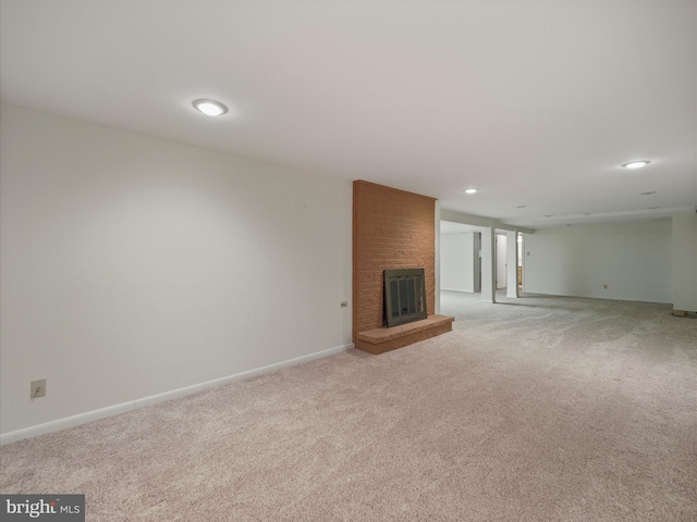 unfurnished living room with light carpet and a fireplace