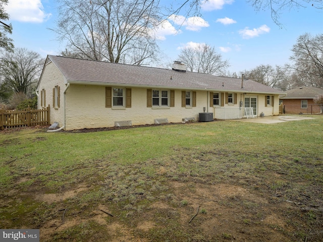 rear view of property featuring cooling unit, a yard, and a patio area