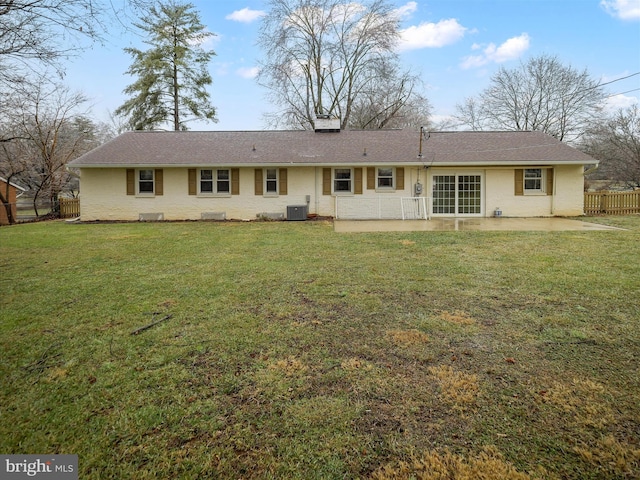 rear view of property featuring a yard, central air condition unit, and a patio area