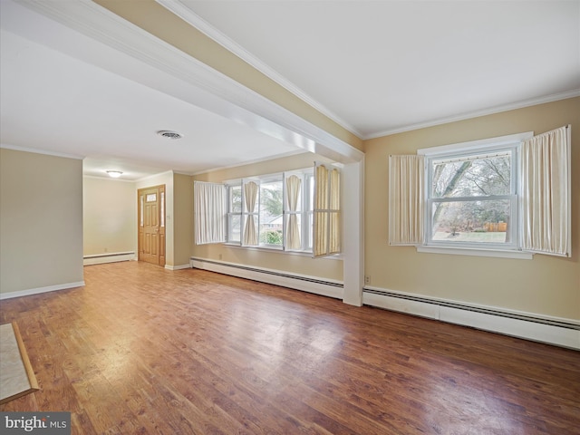 spare room with hardwood / wood-style flooring, a healthy amount of sunlight, crown molding, and a baseboard heating unit