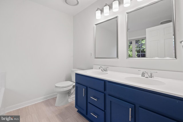 full bathroom featuring double vanity, toilet, and baseboards