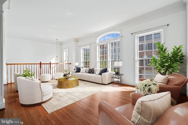 living room featuring hardwood / wood-style floors, ornamental molding, and baseboards