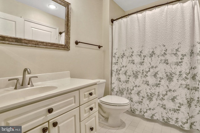 bathroom with tile patterned flooring, vanity, and toilet