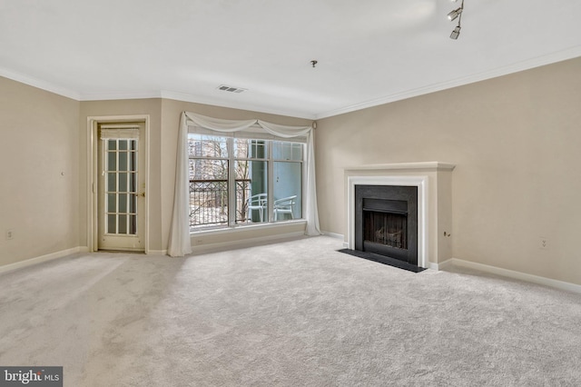 unfurnished living room featuring crown molding, track lighting, and light carpet