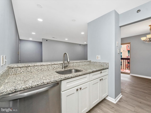 kitchen with sink, dishwasher, white cabinets, and light stone countertops