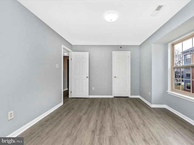 unfurnished bedroom with hardwood / wood-style floors