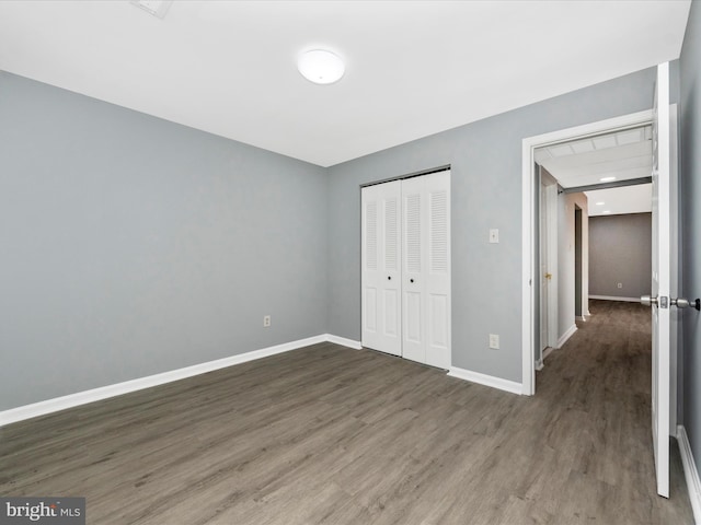 unfurnished bedroom featuring dark wood-type flooring and a closet