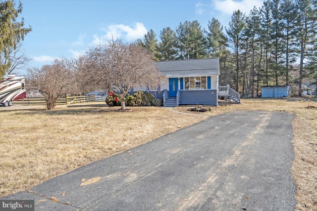 view of front of house with covered porch and a front lawn