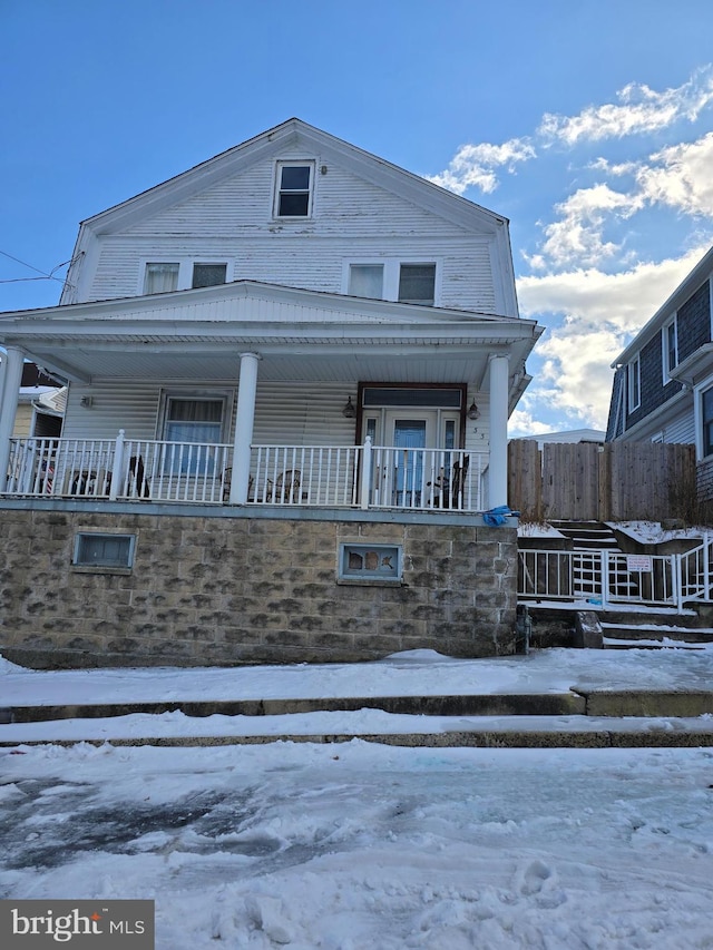 snow covered property featuring a porch