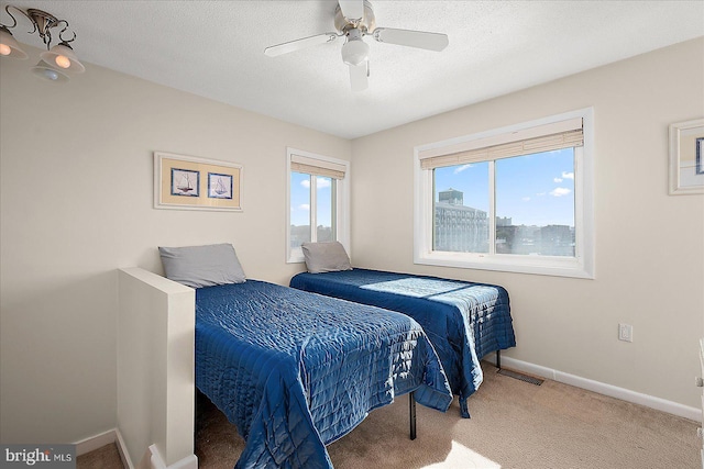 carpeted bedroom with ceiling fan and a textured ceiling