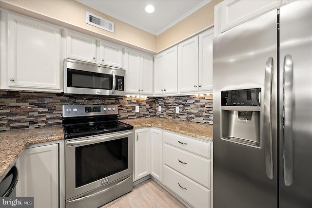 kitchen with crown molding, white cabinetry, stainless steel appliances, light stone counters, and tasteful backsplash