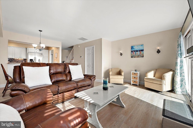 living room featuring a chandelier and light hardwood / wood-style floors