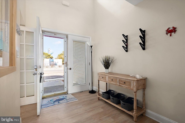 entrance foyer with french doors and light hardwood / wood-style flooring