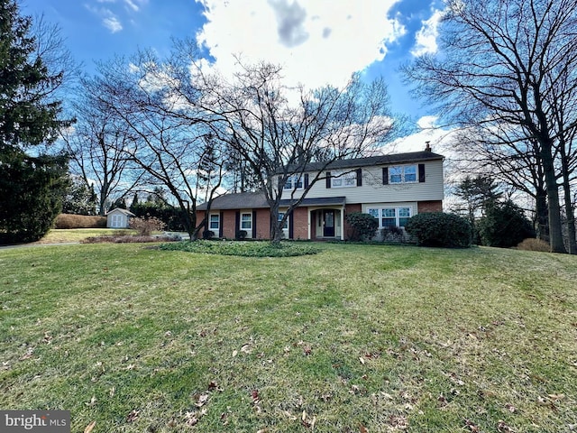 view of front of home featuring a storage unit and a front lawn