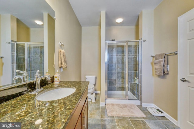 bathroom featuring vanity, toilet, and a shower with door