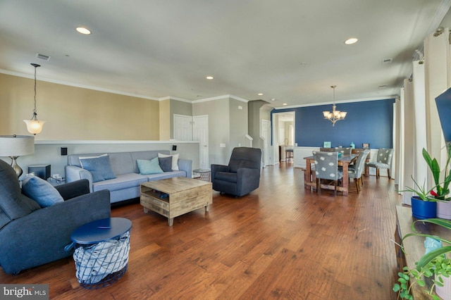 living room featuring crown molding, hardwood / wood-style floors, and a notable chandelier