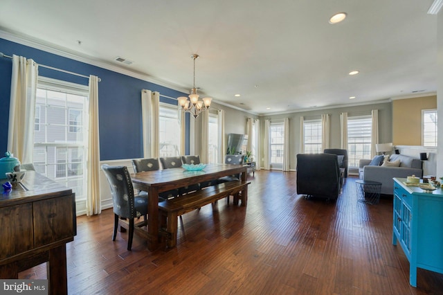 dining room featuring ornamental molding, dark wood-type flooring, and a notable chandelier