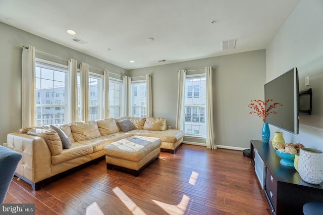 living room featuring dark hardwood / wood-style floors and a healthy amount of sunlight