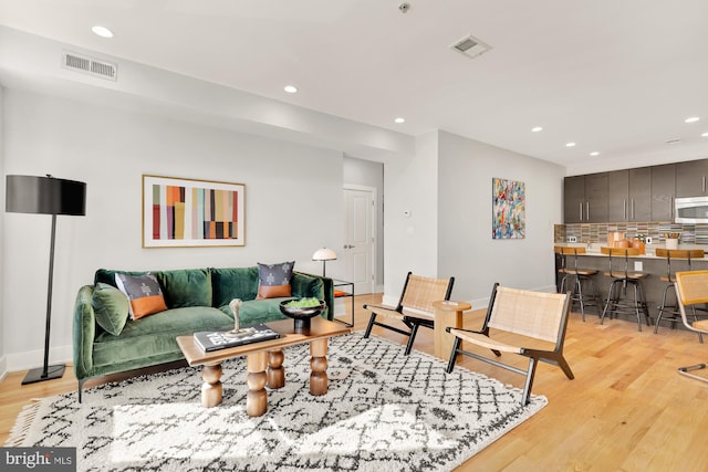 living area featuring recessed lighting, visible vents, and light wood-style floors