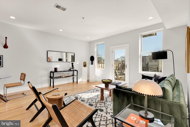 living room featuring recessed lighting, visible vents, baseboards, and wood finished floors