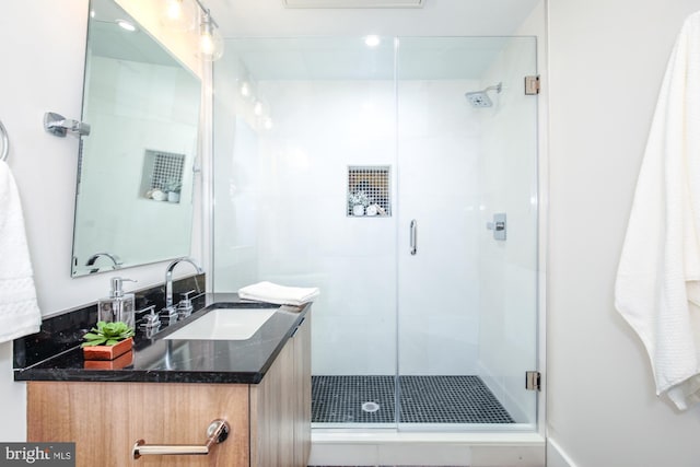 bathroom featuring vanity and a shower with shower door