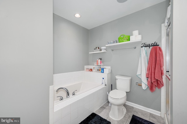 bathroom featuring toilet, tile patterned flooring, and tiled tub