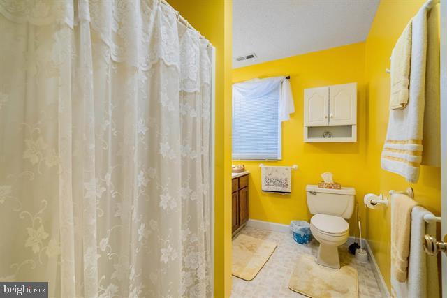 bathroom featuring vanity, tile patterned flooring, and toilet