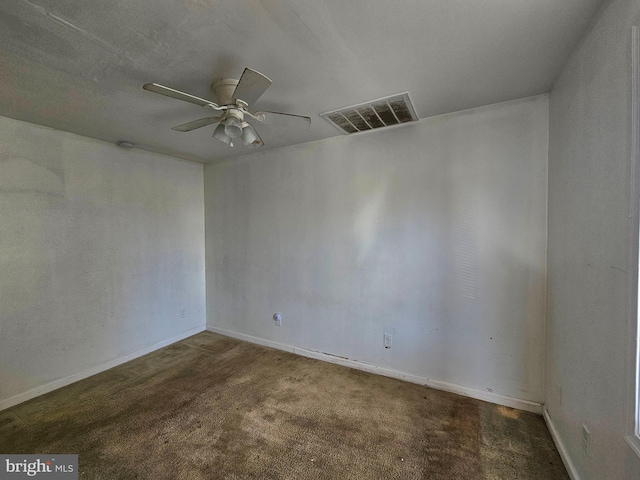 empty room featuring ceiling fan and dark carpet