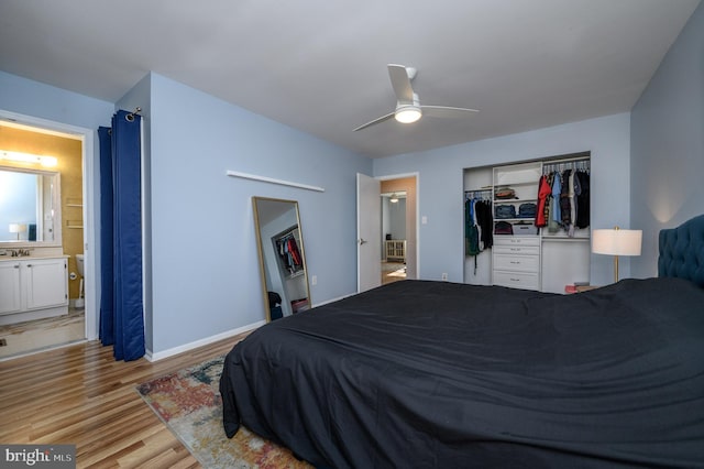 bedroom with light hardwood / wood-style flooring, a closet, ensuite bath, ceiling fan, and sink