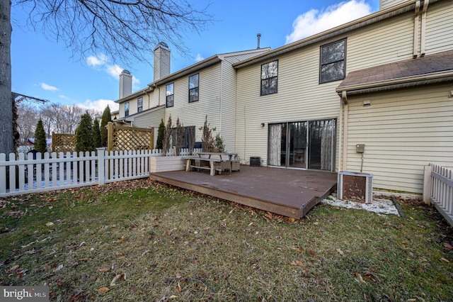 back of house with a deck, cooling unit, and a lawn