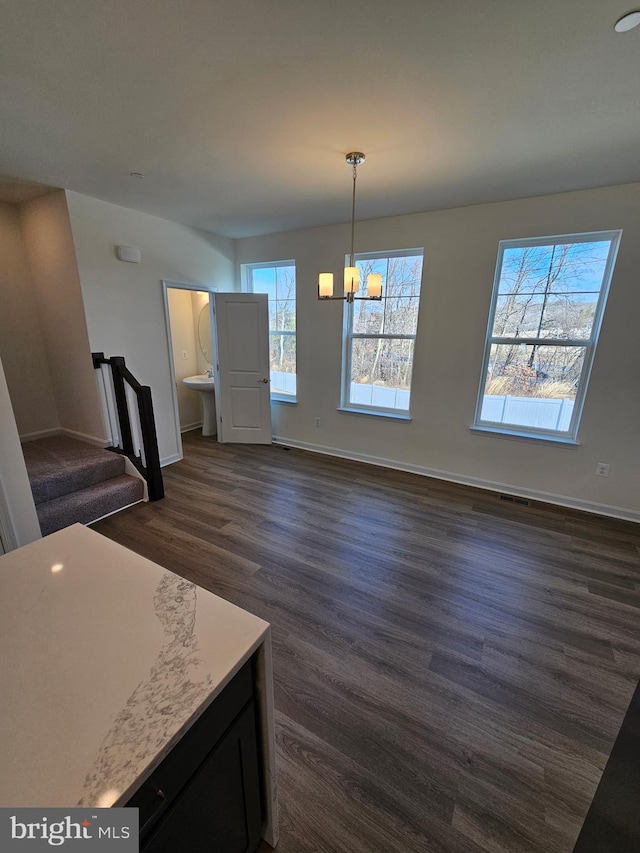 interior space with dark hardwood / wood-style flooring, a chandelier, sink, and hanging light fixtures