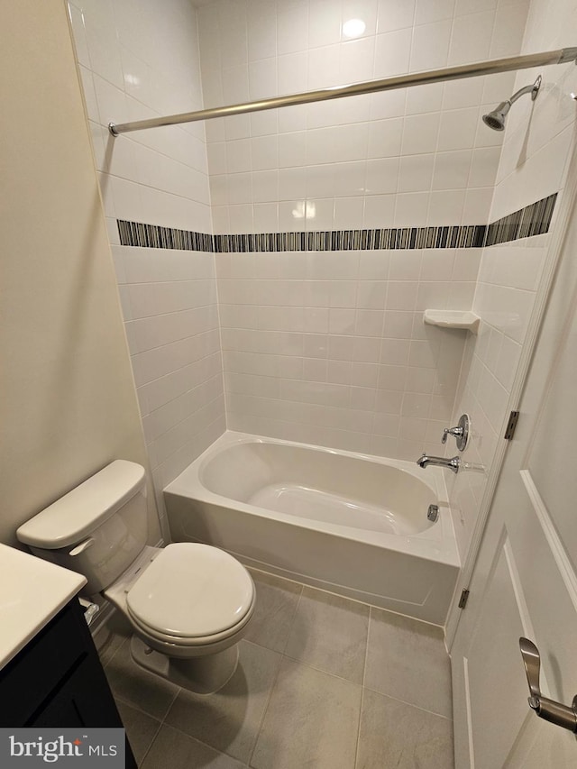 full bathroom featuring tiled shower / bath, vanity, tile patterned floors, and toilet